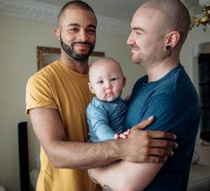 two fathers holding baby